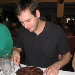 Trying to cut my birthday cake in 18 pieces. It was a delicious chocolate mudcake.