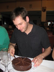 Trying to cut my birthday cake in 18 pieces. It was a delicious chocolate mudcake.